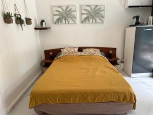 a bedroom with a bed with a yellow blanket at Kaz' Kiki Coco in Folle Anse