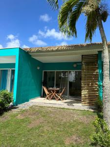 a blue house with a table and a palm tree at Kaz' Kiki Coco in Folle Anse