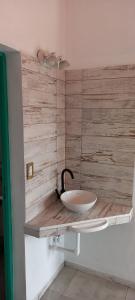 baño con lavabo en una pared de madera en Los Cactus en Tafí del Valle