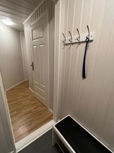 um corredor com uma porta e um banco num quarto em Koselig rom i rolige omgivelser em Åmot