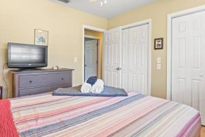 a bedroom with a bed with a tv on a dresser at Riverfront Oasis Stunning Inside and Out Remodeled 3BR Riverfront Home with Hot Tub and personal paddle boats with Access to the Gulf in Riverview