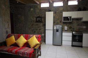 salon z czerwoną kanapą i żółtymi poduszkami w obiekcie Cha'skas Checkta Eco-Lodge w mieście Santa Rosa de Quives