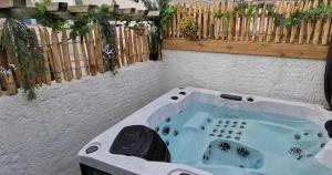 uma banheira de hidromassagem num quintal com uma cerca em La Maison du pêcheur - Jacuzzi em Jard-sur-Mer