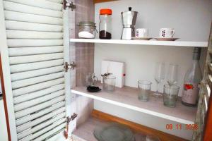 CrespoPipí Cucú - Apartamentos Completos Planta Baja的架子上装有玻璃杯和其他物品