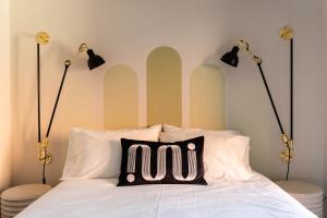 a bed with two lights and a pillow on it at Place Royale by Luxury In Transit in Montréal