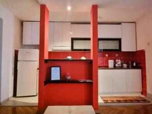 uma cozinha com armários vermelhos e brancos e um frigorífico em A&P Apartments em Skopje