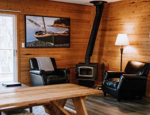 a living room with a stove and a wooden wall at Page's Resort & Marina in Gabriola