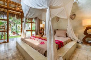 a bedroom with a bed with a canopy at Villa Burung Gili Air Authentic 3-Bedroom Bamboo Villa with Private Pool in Gili Air