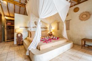 a bedroom with a bed with a canopy at Villa Burung Gili Air Authentic 3-Bedroom Bamboo Villa with Private Pool in Gili Air