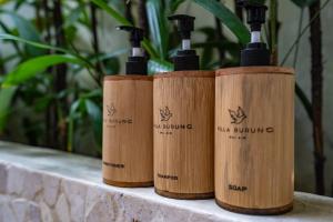 four bottles of wine sitting on a counter at Villa Burung Gili Air Authentic 3-Bedroom Bamboo Villa with Private Pool in Gili Air