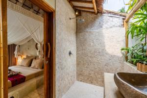 a bathroom with a shower and a bed and a tub at Villa Burung Gili Air Authentic 3-Bedroom Bamboo Villa with Private Pool in Gili Air