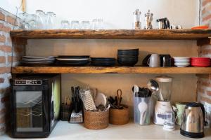 a kitchen shelf with plates and utensils at Villa Burung Gili Air Authentic 3-Bedroom Bamboo Villa with Private Pool in Gili Air