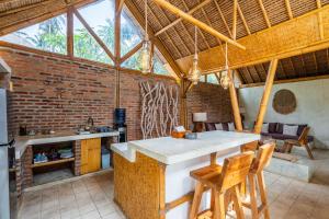 a kitchen with a table and chairs in a room at Villa Burung Gili Air Authentic 3-Bedroom Bamboo Villa with Private Pool in Gili Air