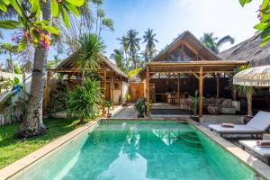 a villa with a swimming pool and a house at Villa Burung Gili Air Authentic 3-Bedroom Bamboo Villa with Private Pool in Gili Air