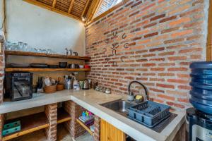 a kitchen with a sink and a brick wall at Villa Burung Gili Air Authentic 3-Bedroom Bamboo Villa with Private Pool in Gili Air