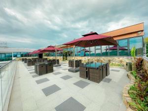 Venus Royale Hotel في كورون: فناء به طاولات ومظلات على مبنى