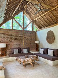 a living room with a couch and a table at Villa Burung Gili Air Authentic 3-Bedroom Bamboo Villa with Private Pool in Gili Air