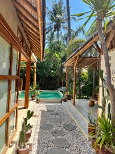 a backyard with a swimming pool and a house at Villa Burung Gili Air Authentic 3-Bedroom Bamboo Villa with Private Pool in Gili Air