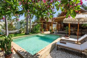 an image of a swimming pool in front of a house at Villa Burung Gili Air Authentic 3-Bedroom Bamboo Villa with Private Pool in Gili Air