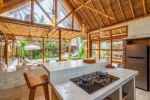 - une cuisine avec un îlot équipé d'un four avec plaques de cuisson dans l'établissement Villa Burung Gili Air, à Gili Air