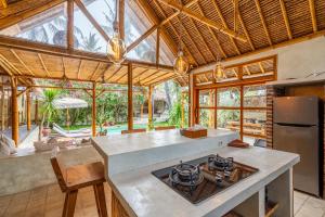 a kitchen with an island with a stove top oven at Villa Burung Gili Air Authentic 3-Bedroom Bamboo Villa with Private Pool in Gili Air
