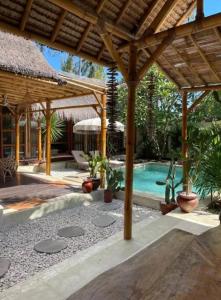 a patio with a swimming pool and a pavilion at Villa Burung Gili Air Authentic 3-Bedroom Bamboo Villa with Private Pool in Gili Air