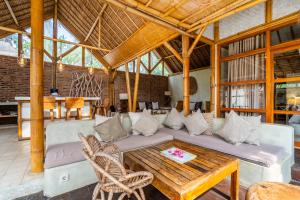 a living room with a couch and a table at Villa Burung Gili Air Authentic 3-Bedroom Bamboo Villa with Private Pool in Gili Air
