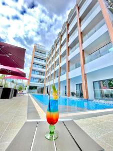 una bebida colorida sentada en una mesa frente a un edificio en Venus Royale Hotel en Corón