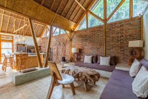 a large living room with a brick wall at Villa Burung Gili Air Authentic 3-Bedroom Bamboo Villa with Private Pool in Gili Air