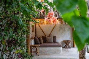 a bench in a garden with plants at Villa Burung Gili Air Authentic 3-Bedroom Bamboo Villa with Private Pool in Gili Air