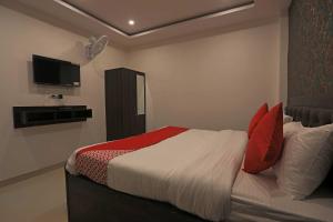 法里達巴德的住宿－OYO Flagship City Residency，一间卧室配有红色和白色枕头的床