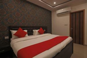 sypialnia z dużym łóżkiem z czerwonymi poduszkami w obiekcie OYO Flagship City Residency w mieście Faridabad