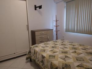 1 dormitorio con 1 cama, vestidor y ventana en Ótimo Apartamento na Praia dos Ingleses Gaivotas 70m do Mar, en Florianópolis