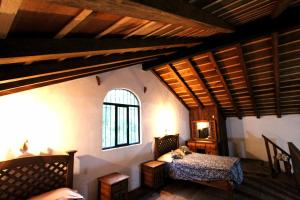 ein Schlafzimmer mit einem Bett und einem Fenster in einem Zimmer in der Unterkunft El Búho, Sauna, cabañas, camping in San Cristóbal de las Casas