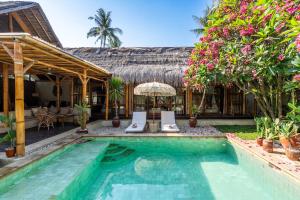 a villa with a swimming pool and a resort at Villa Burung Gili Air Authentic 3-Bedroom Bamboo Villa with Private Pool in Gili Air
