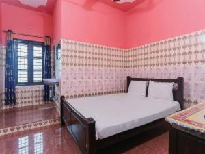 een slaapkamer met een groot bed in een roze kamer bij OYO Hotel Sree Bhadra Tourist Home in Kollam