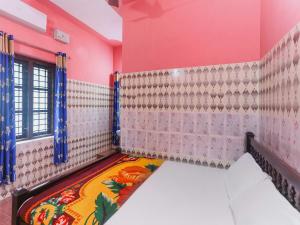 een kamer met roze muren en een kleurrijk tapijt bij OYO Hotel Sree Bhadra Tourist Home in Kollam