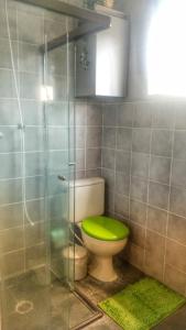 a bathroom with a toilet with a green seat at Apartamento em Guarujá Praia do Tombo, 300mts do mar - TOMBO BEACH HOST in Guarujá