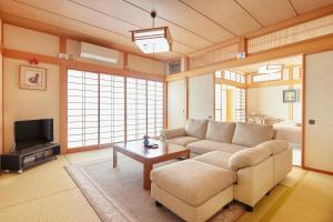 sala de estar con sofá y TV en Guesthouse Ichigo Ichie Nikko en Nikko