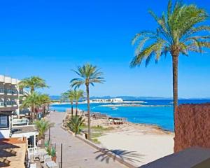 een uitzicht op een strand met palmbomen en de oceaan bij APT Pujolet, Es Pujols-Formentera vacaciones in Es Pujols