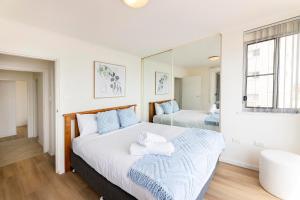 a bedroom with a large bed and a mirror at El Sandi Unit 06 in Forster