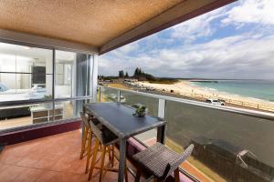 a balcony with a table and chairs and a view of the beach at El Sandi Unit 06 in Forster