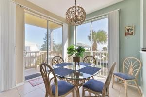 a dining room with a table and chairs and a balcony at Ocean Club At Turtlemound 107 - 2 Bedroom 1 Bath in New Smyrna Beach