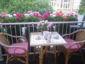 uma mesa e cadeiras com flores numa varanda em Staten Hotel em Haia