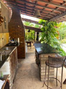 an outdoor kitchen with a counter and a table at Butterfly House in Flecheiras