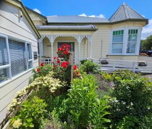 una casa con un jardín de flores delante de ella en MAGNOLIA HOUSE en Featherston