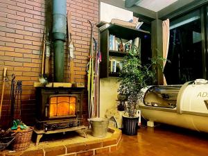 a brick wall with a fireplace in a living room at Garden Pension Obergurgl in Hakuba
