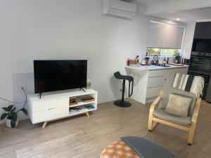 uma sala de estar com uma televisão de ecrã plano num armário branco em Conjola Inn-let - Self Contained Unit - Lake Conjola em Manyana
