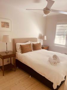 - une chambre avec un lit et des serviettes dans l'établissement Pearl House By Coast Holidays, à Pearl Beach