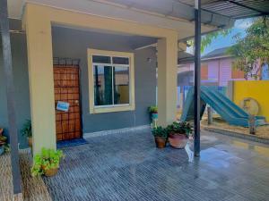 a house with a playground with a slide and potted plants at D'NARS HOMESTAY KEMAMAN in Cukai